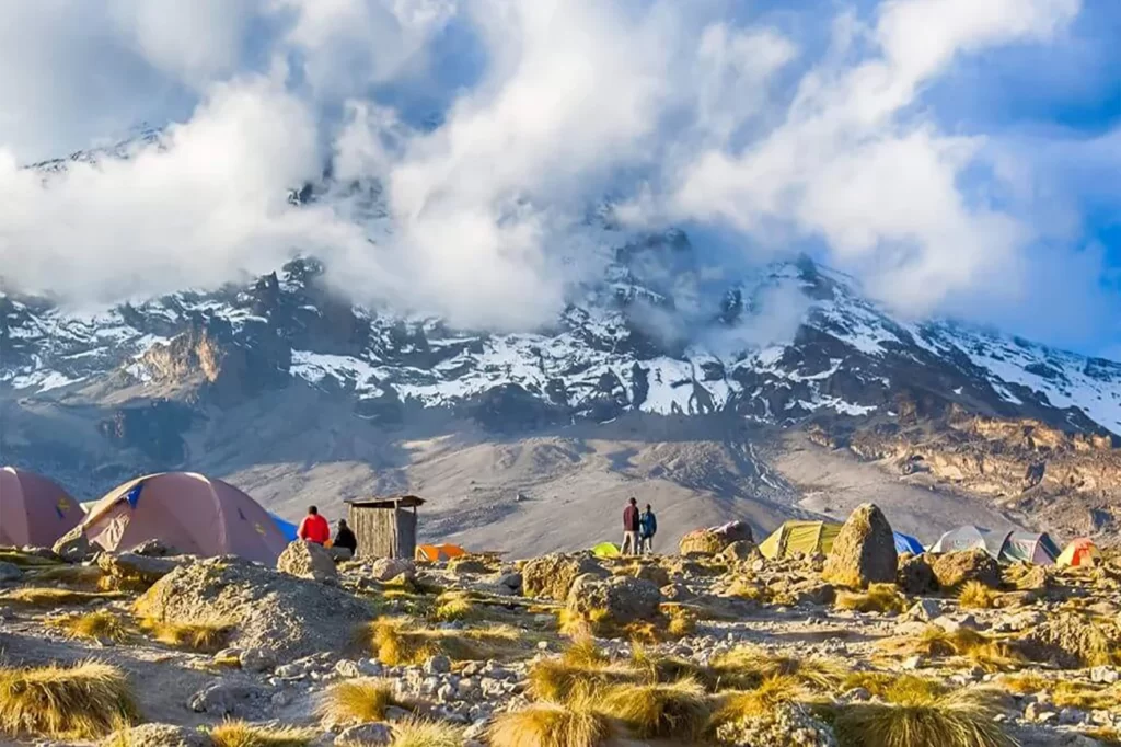 a group of people standing around tents in the desert